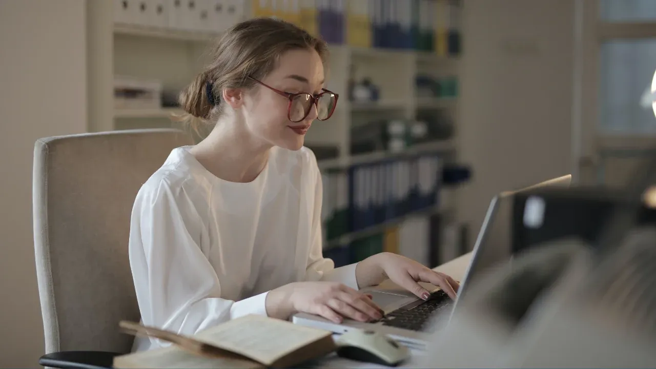 Woman In White Long Sleeve Shirt Using A Laptop