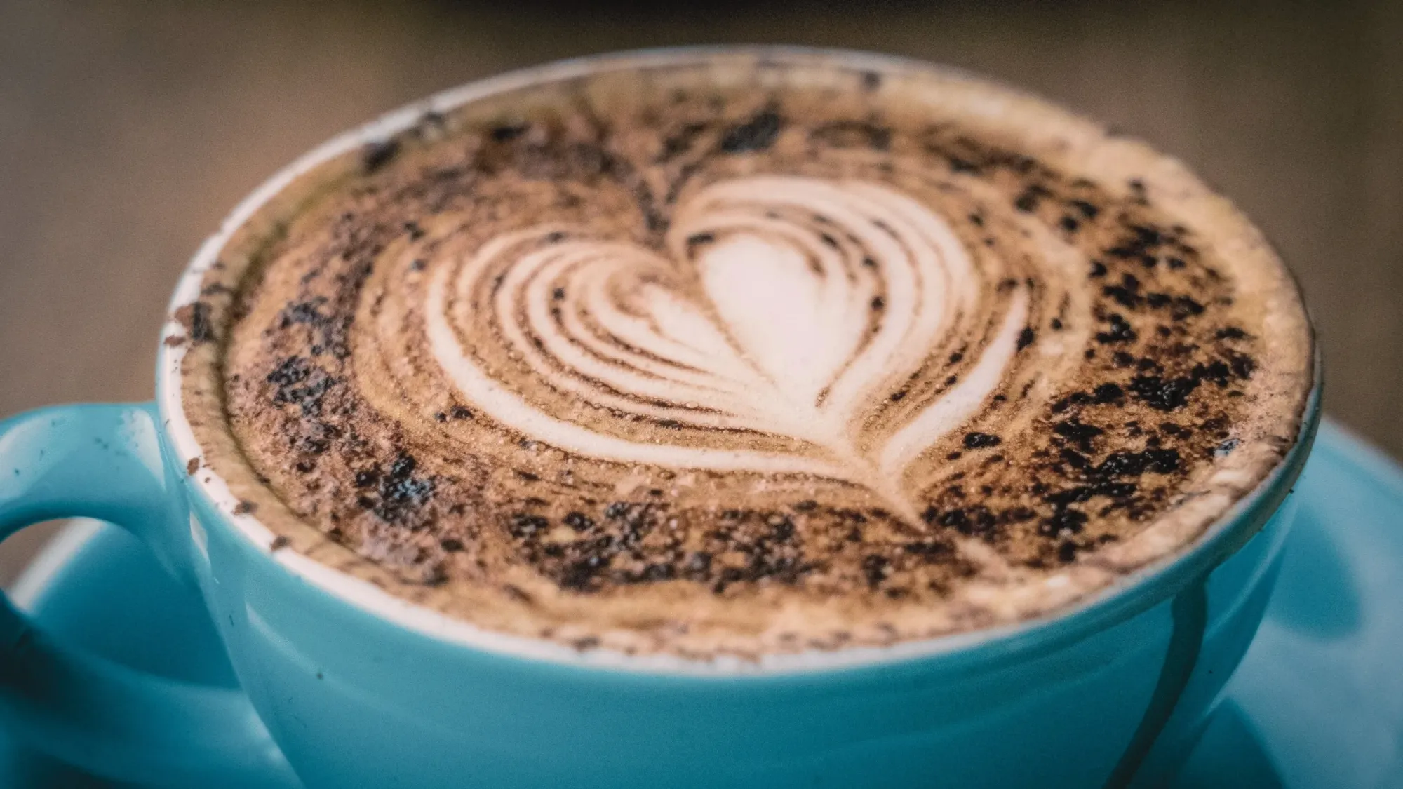Cup of coffee with a heart shape in top foam.